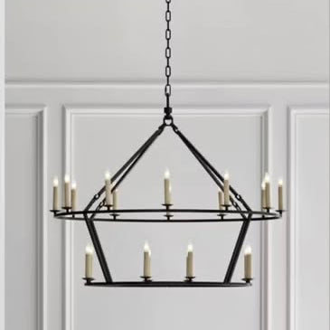 Chandelier hanging in a room with white walls and wooden paneling.